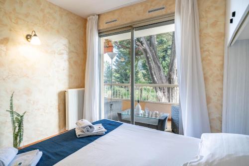 um quarto com uma cama e uma grande janela em Spacious apartment at a 5 min walk from the beach em Antibes