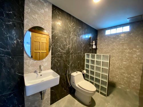 a bathroom with a sink and a toilet and a mirror at Blue Aura Pool Villa in Nai Yang Beach