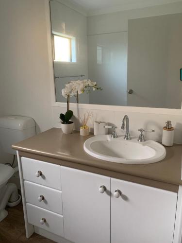 a bathroom with a sink and a mirror at Quintessential Kewarra in Kewarra Beach
