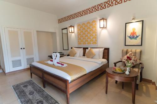 a hotel room with a bed and a table at Yog Niketan By Sanskriti in Rishīkesh