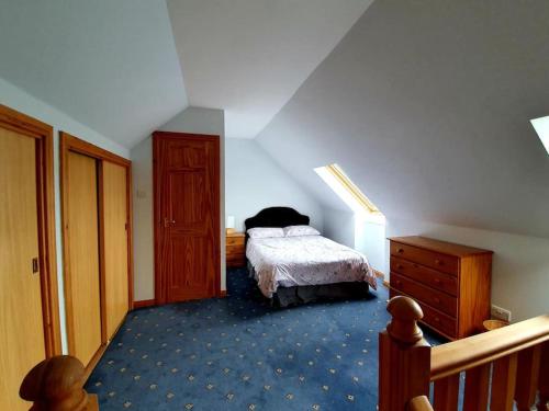 a bedroom with a bed and a wooden dresser at OneRavensLane in Stornoway