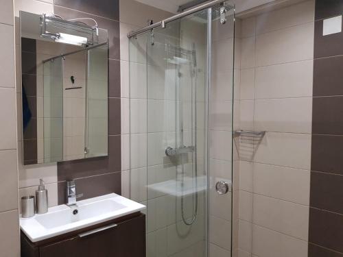 y baño con ducha acristalada y lavamanos. en Bay View Modern Apartment, en Albufeira