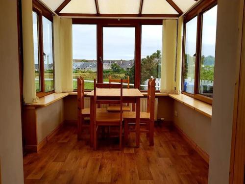 - une salle à manger avec une table, des chaises et des fenêtres dans l'établissement OneRavensLane, à Stornoway