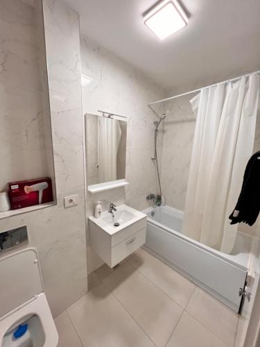 a white bathroom with a sink and a toilet at Central Metropolitan Bright 2 in Iaşi