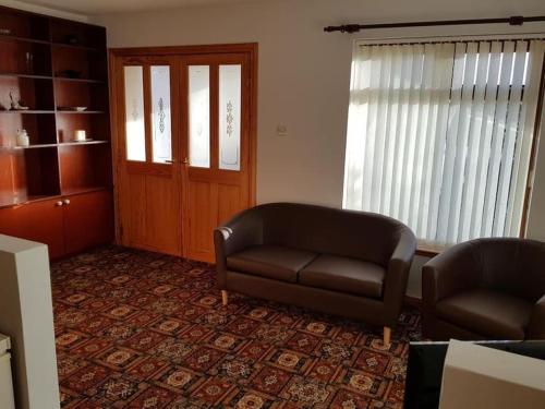 a living room with a couch and a chair at OneRavensLane in Stornoway