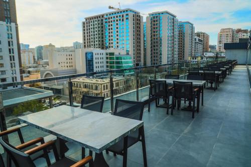a row of tables and chairs on the roof of a building at Iris Hotel Baku in Baku