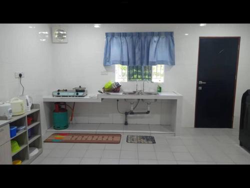 uma cozinha com um lavatório e uma janela em Villa Anggun em Papar