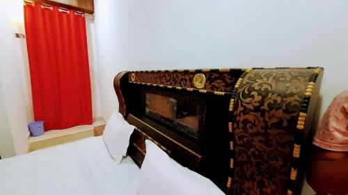 um quarto com uma cama com uma cortina vermelha em OYO Rajeswari Continental em Kanpur