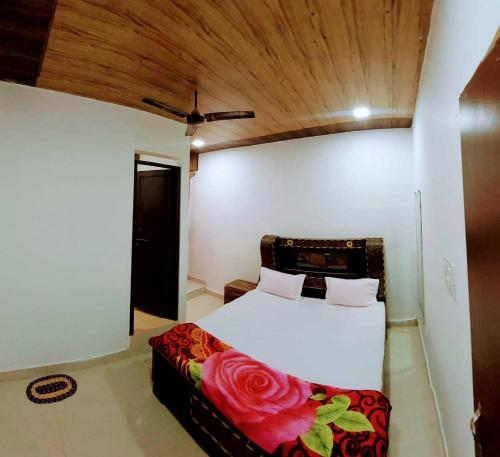 um quarto com uma cama branca e um banco com rosas em OYO Rajeswari Continental em Kānpur
