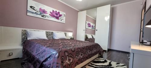 a bedroom with a bed with a purple bedspread at M.Dosoftei 126 in Chişinău