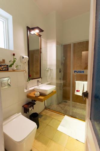 a bathroom with a toilet and a sink and a shower at Yog Niketan By Sanskriti in Rishīkesh