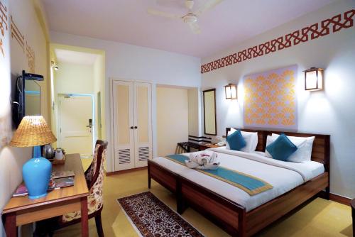 a bedroom with a bed and a desk and a desk at Yog Niketan By Sanskriti in Rishīkesh