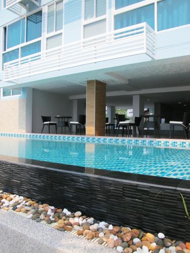 a swimming pool in front of a building at Nantra Pattaya Baan Ampoe Beach in Na Jomtien