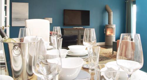 a table with wine glasses on it with a fireplace at STUNNING LODGE MINUTES FROM THE SEA AND GOLF COURSE in Longniddry