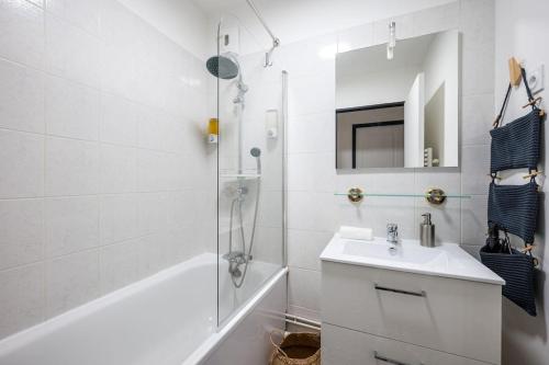 une salle de bain blanche avec un lavabo et une douche dans l'établissement L’Ébène-Paris, Stade de France, Parking & Balcon, à Saint-Denis