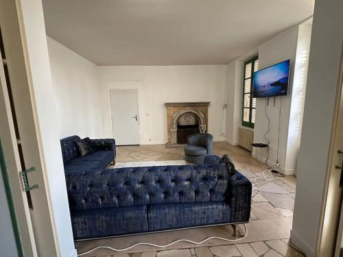 sala de estar con sofá azul y chimenea en Magnifique, logement Melun, en Le Mée-sur-Seine