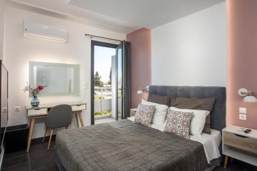 a bedroom with a bed and a desk and a mirror at Faliro Hotel in Faliraki