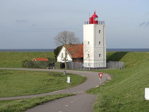 a lighthouse on a hill next to a road at B&B Het Molensteegje in Andijk