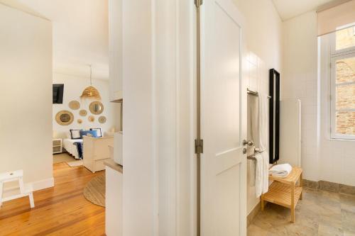 um corredor branco com uma porta que leva a uma sala de estar em Alcácer Studio em Alcácer do Sal