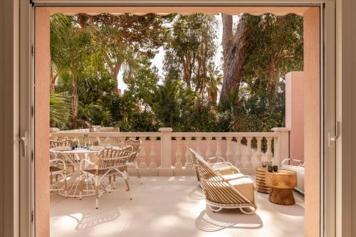 a patio with a table and chairs and trees at Maison Carla Rosa Cannes in Cannes
