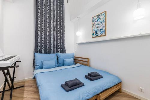a bedroom with a bed with blue sheets and a desk at Venus Apartments - City Park II in Budapest