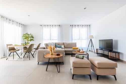 uma sala de estar com um sofá e cadeiras e uma televisão em Apartamento Dora Maar I em Marbella