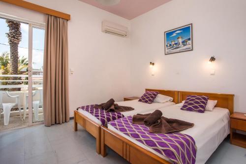 a bedroom with two beds and a balcony at Faliro Hotel in Faliraki