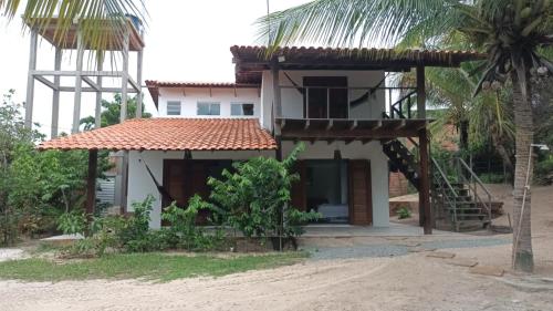 a house on the beach with a palm tree at Casa Serena in Atins