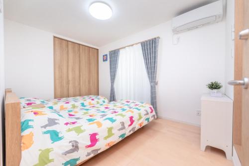 a bedroom with a bed with a colorful comforter at 合綠の宿 202 in Osaka