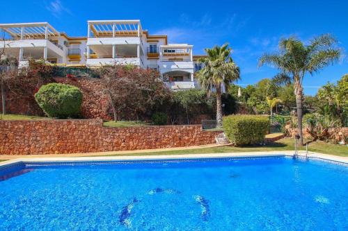 a villa with a swimming pool in front of a house at Ap. con vistas panorámicas in Benalmádena