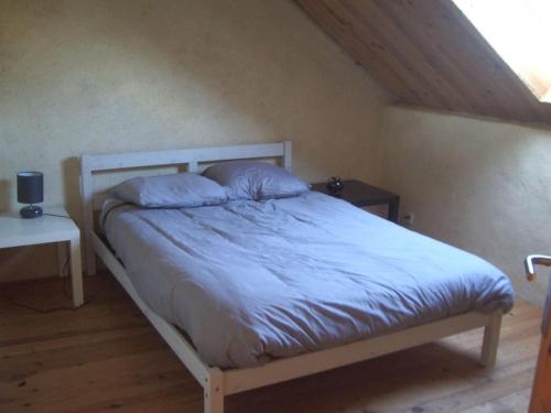 Schlafzimmer mit einem Bett mit blauer Bettwäsche in der Unterkunft Gîte village des bords de Loire in Montjean-sur-Loire