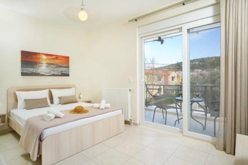 a bedroom with a bed and a balcony at Nik-Ntin Villa Deluxe in Prinos