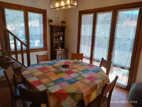 uma sala de jantar com uma mesa colorida com cadeiras e janelas em Casa Rural Ubaba em Artaza