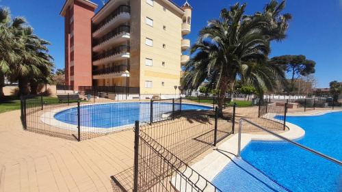 a swimming pool in front of a building at El Faro de Canet in Canet de Berenguer