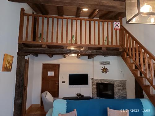 sala de estar con escalera, sofá y TV en Casa Rural Ubaba, en Artaza