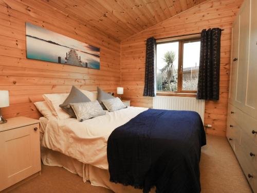 a bedroom with a bed in a wooden cabin at Seascape Retreat in Ilfracombe