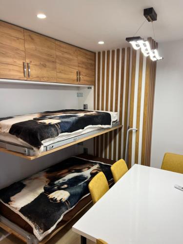 Cette chambre comprend 2 lits superposés et une table. dans l'établissement Beach apartment, à Durrës