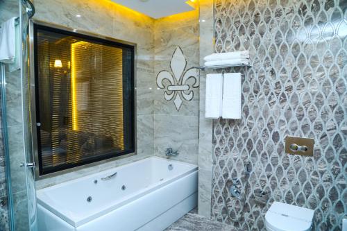 a bathroom with a tub and a toilet and a sink at Iris Hotel Baku in Baku
