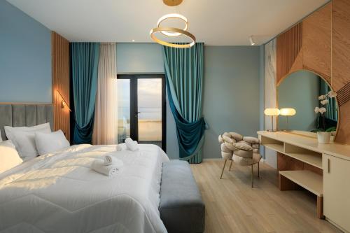 1 dormitorio con 1 cama blanca grande y escritorio en Hotel Brilant Saranda, en Sarandë