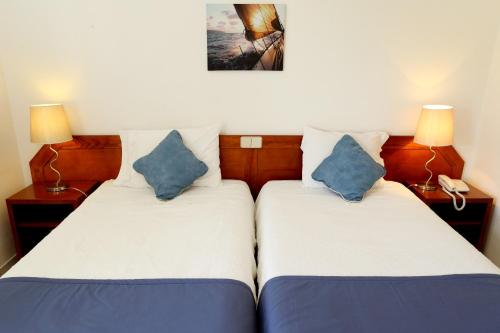 two beds sitting next to each other in a room at Mira Parque in Albufeira