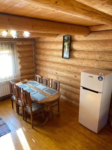 eine Küche mit einem Tisch und einem Kühlschrank im Zimmer in der Unterkunft Smerekovyi Dvir in Poljana