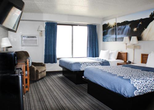 a hotel room with two beds and a window at Days Inn by Wyndham Sioux Falls in Sioux Falls