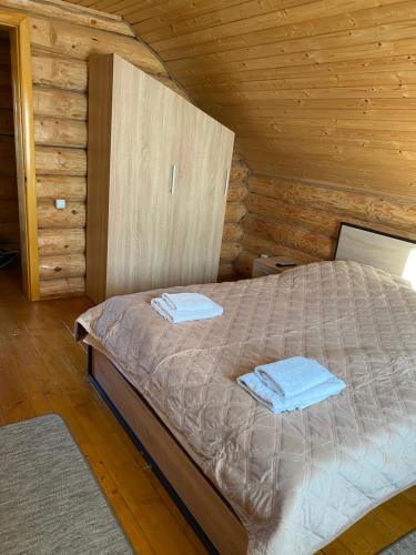 a bedroom with a bed in a wooden cabin at Smerekovyi Dvir in Polyana