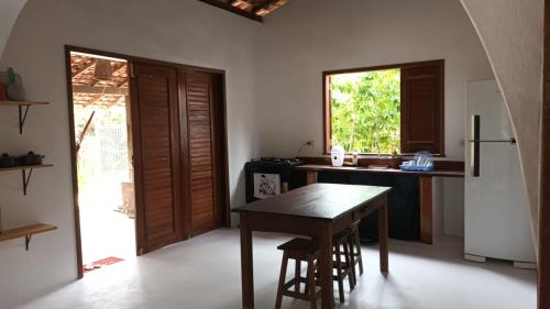 a kitchen with a wooden table and a refrigerator at Casa Serena in Atins