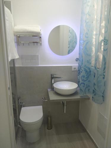 a bathroom with a toilet and a sink and a mirror at Casa vacanze Venere in Balestrate