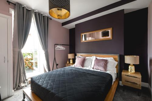 a bedroom with purple walls and a bed with pillows at Central Brighton few Steps from Brunswick Square in Brighton & Hove