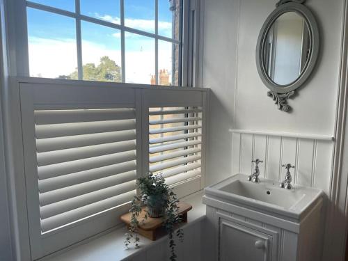 a bathroom with a sink and a mirror and a window at Station House, Gilling in Gilling East