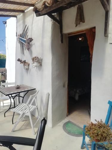 a patio with a table and chairs and a door at Sweet Old House in Marsala