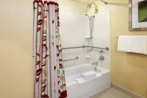 a bathroom with a white tub and a shower curtain at Courtyard Newark Granville in Newark