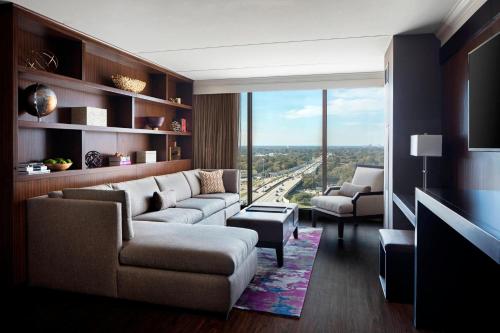 a living room with a couch and a large window at Baton Rouge Marriott in Baton Rouge